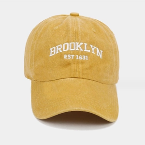 Detailed embroidery of white BROOKLYN text on ginger washed cotton baseball cap