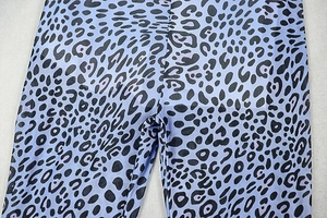 Detailed close-up of blue leopard print fabric and high-quality stitching on jumpsuit