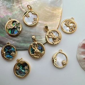 Detailed close-up of 18K gold plated charms with abalone shell and mother of pearl designs