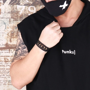 Detail of multi-layer black leather woven bracelet with beads on a male model wrist