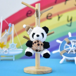 Detailopname van een schattige pluche panda sleutelhanger met koekje op standaard
