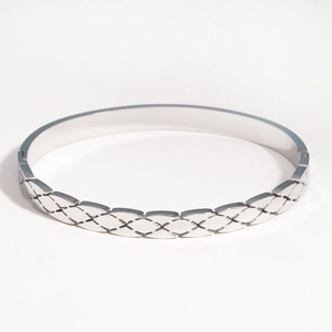 Détail macro d'un bracelet en acier titane argenté avec motif géométrique matelassé