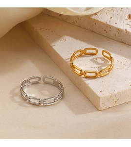 Detail of gold and silver chain link rings on beige stone and silk background