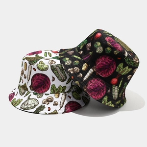 Reversible bucket hats in black and white with vibrant hand-drawn vegetable illustrations