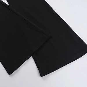 Detail view of black flared trousers hem showing fine stitching and smooth fabric texture