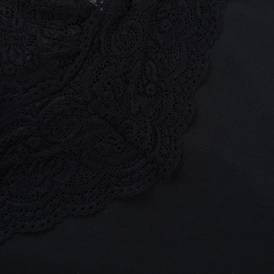 Close-up of intricate black lace stitching and texture on a French style evening dress