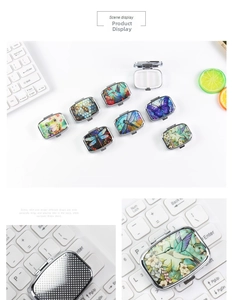 Detail of portable square metal pill box featuring floral nature prints and dual compartments