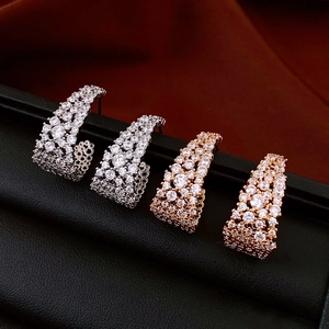 Gros plan de boucles d'oreilles en U en argent et or rose avec pavé de zircons