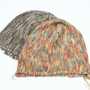 Colorful speckled knit beanies in gray and multi-color with distressed hole details