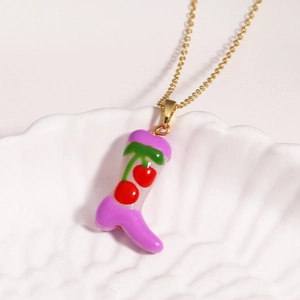 Golden necklace with purple boot pendant featuring red cherry details in a shell dish