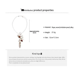 Ethnic necklace detail showing sun charm, wooden beads, and feathers with size markers