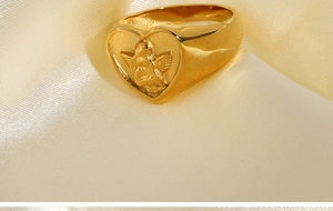 Macro shot of 18k gold plated stainless steel heart ring with cupid angel relief
