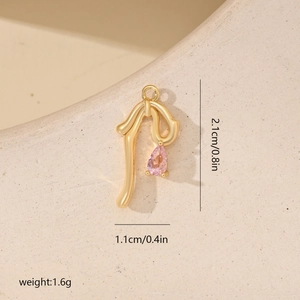 Macro shot of gold bow pendant with pink teardrop zircon and size dimensions in cm and inches