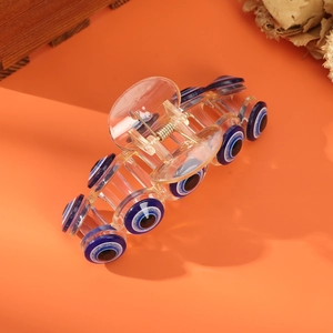 Quirky orange pumpkin hair claw clip with blue devil eye patterns on a solid backdrop