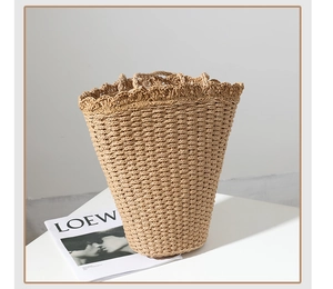 Detail of hand-woven straw bucket bag featuring ruffled edges and a drawstring lining