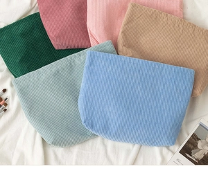 Close-up of corduroy makeup bags in various pastel colors with soft ribbed texture