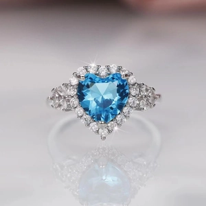 Macro shot of silver ring with heart-shaped topaz blue stone and small white diamonds