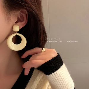 Boucles d'oreilles créoles vintage en acrylique crème avec aiguille en argent sur mannequin