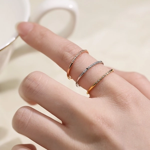 Three stacked zircon row rings in rose gold, silver, and gold finish on a hand