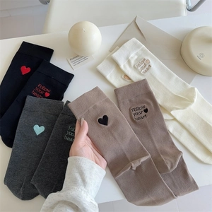 Close-up of heart embroidery and Follow Your Heart lettering on cotton crew socks