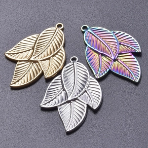 Macro detail of 18k gold and silver leaf pendants with realistic embossed textures