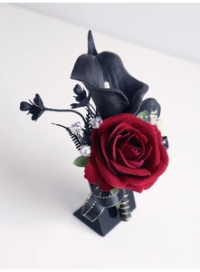 Détail de la boutonnière en rose de velours rouge et calla noir avec strass brillants