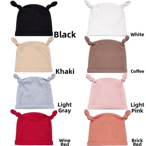 Vue à plat de huit bonnets bébé en maille côtelée avec bois noués en plusieurs coloris