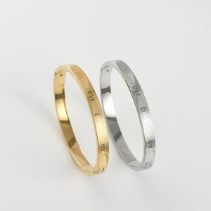 Detailed view of matte gold and silver stainless steel love bangles with mesh texture