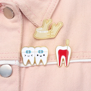 Detailed enamel pins featuring jaw and tooth anatomy on a pink denim jacket