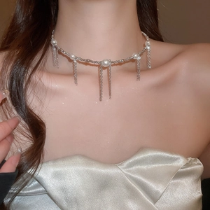 Close-up of elegant pearl tassel choker necklace with delicate silver chain on model