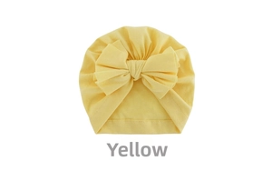 Detail of soft yellow baby turban hat featuring a large layered cotton knot bow design