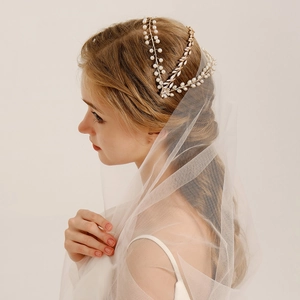 Detail of baroque bridal headband with layered pearls and rhinestones on a gold band