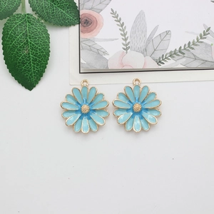 Detailed view of two light blue enamel daisy charms with gold trim for DIY jewelry
