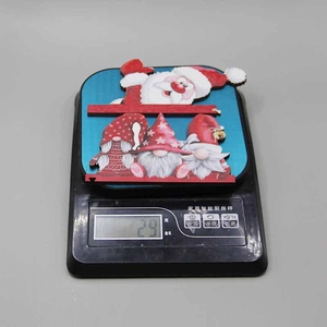Detail showing Christmas wooden door corner ornament weight of 29g on an electronic scale