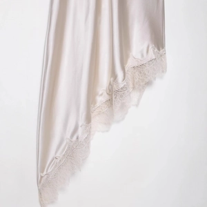 Elegant champagne silk satin dress featuring intricate white lace hemline details