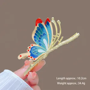 Detail view of large butterfly hair claw clip with blue enamel and gold metal frame