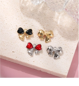 Detail view of bow-shaped alloy pendants with glass rhinestones in multiple colors
