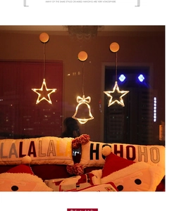 Close-up of LED suction cup window lights featuring star and bell shapes in warm yellow glow