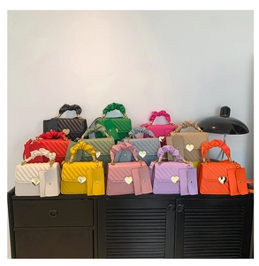 Collection of small quilted leather square bags in various colors with heart-shaped clasps