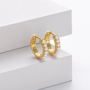 Detailed macro view of S925 sterling silver gold-plated earrings with pearls