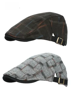 Detail of classic plaid newsboy caps with adjustable metal buckles in brown and grey