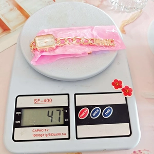Weight measurement of stylish gold women's watch at 47g on a digital scale