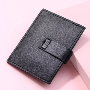 Detail of black pebbled leather card holder with secure buckle and fine stitching