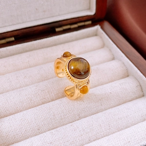 Dettaglio di un anello vintage dorato con pietre occhio di tigre in scatola di velluto