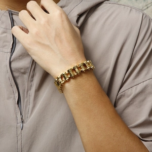 Close-up of a gold-plated stainless steel heavy bike chain bracelet on a male wrist