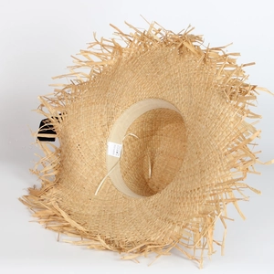 Detail of 100% raffia straw hat showing the frayed edge texture and inner sweatband