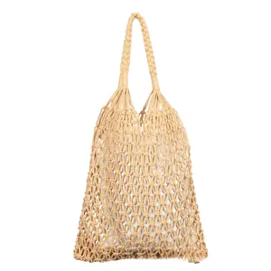 Close-up of beige handmade macramé woven cotton tote bag with hollow net texture