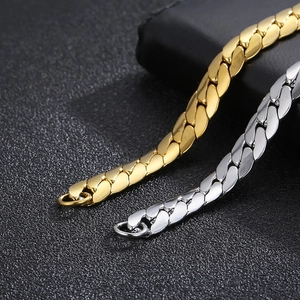 Macro detail of polished gold and silver Cuban curb chains showing flat dense links