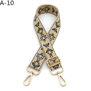 Detail of floral jacquard bag strap with gold metal lobster clasps and embroidery