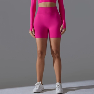 Detail of high-waist seamless fuchsia yoga shorts and crop top with athletic texture